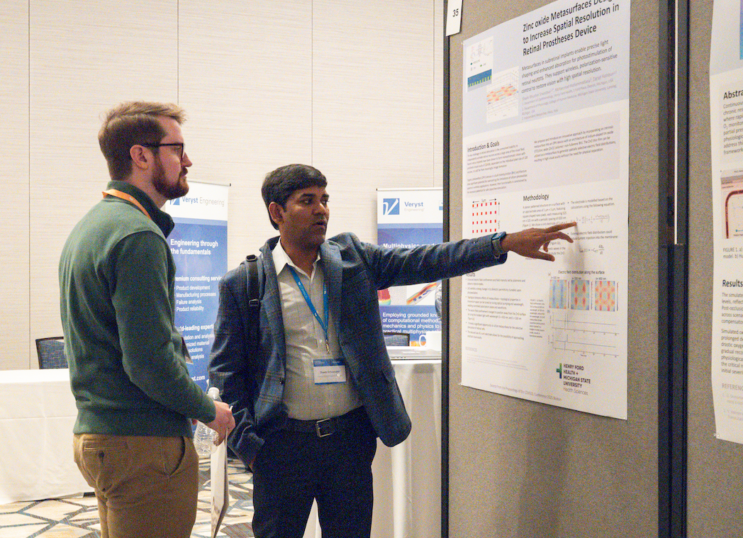A conference attendee discussing their work with a COMSOL engineer.